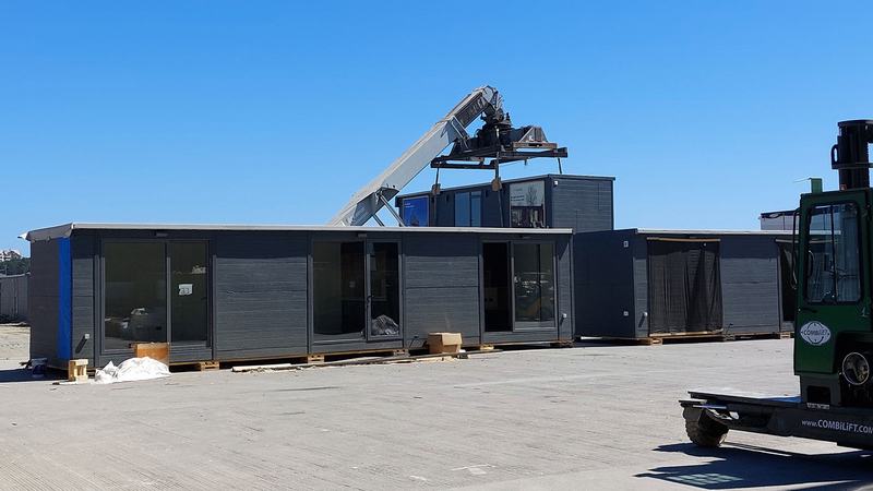 I moduli prefabbricati vengono sollevati e posizionati nella posizione corrispondente mediante una gru.