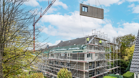 La ristrutturazione seriale con elementi d'intelaiatura in legno offre grandi vantaggi, come ad esempio il notevole miglioramento dell'efficienza energetica e l'estetica accattivante. Copyright: Jannis Wiebusch